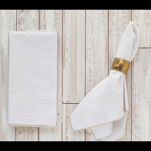 White textured towel with a gold ring on a wooden surface