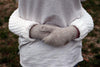 Toddler-size alpaca mittens in natural Suri shades on a neutral background