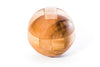Kumiki Japanese wooden ball puzzle assembled on a desk surface