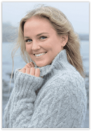 Woman wearing a gray sweater with a blurred background