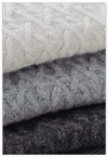 Stack of knitted fabric in white, gray, and black.