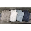 Four knitted vests in different colors on a wooden surface