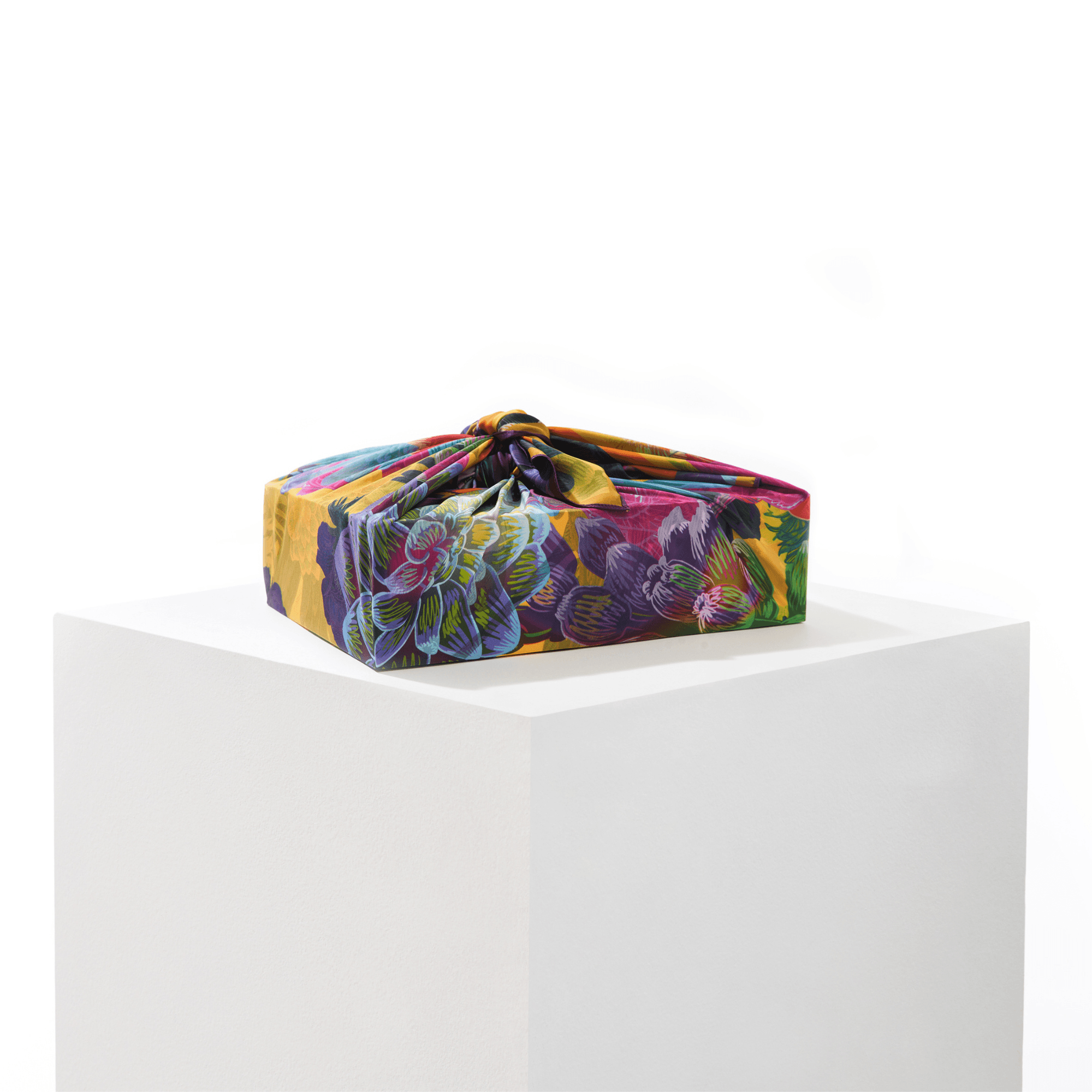 Lilac silk furoshiki wrap tied around a gift, displaying summer floral pattern in lilac and complementary tones