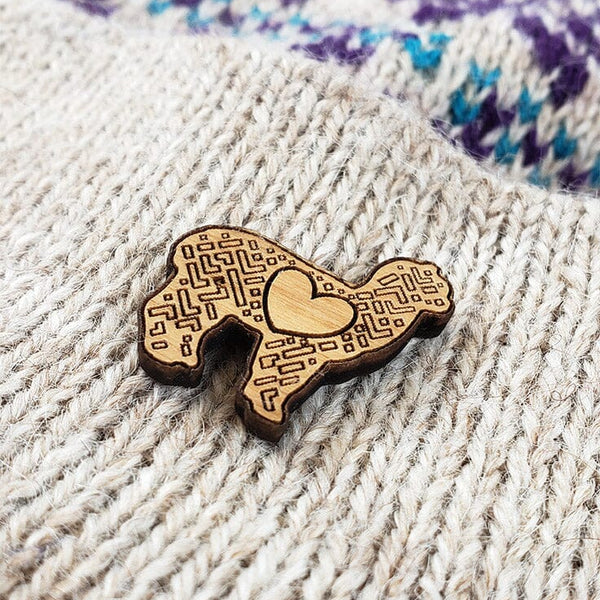 Wooden brooch with heart design on a textured fabric background