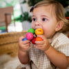 Baby playing with HABA Magica wooden teething toy with smooth colorful beads