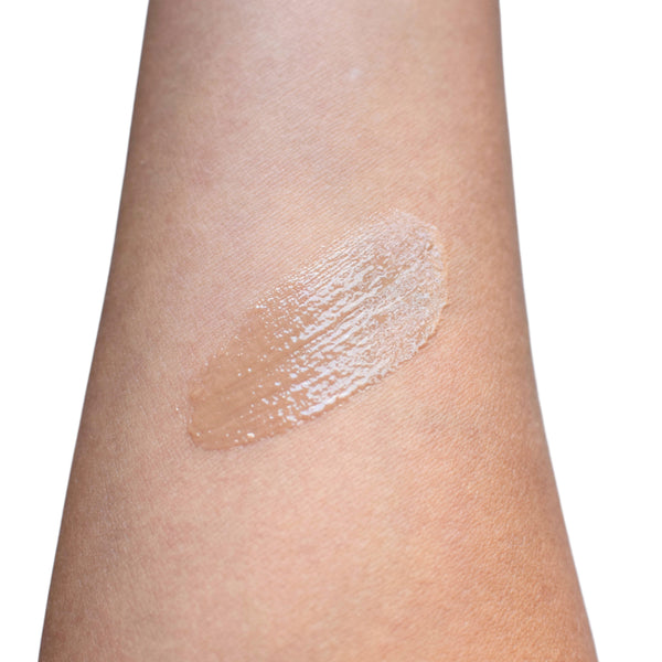 Beige makeup swatch on a person's arm against a white background