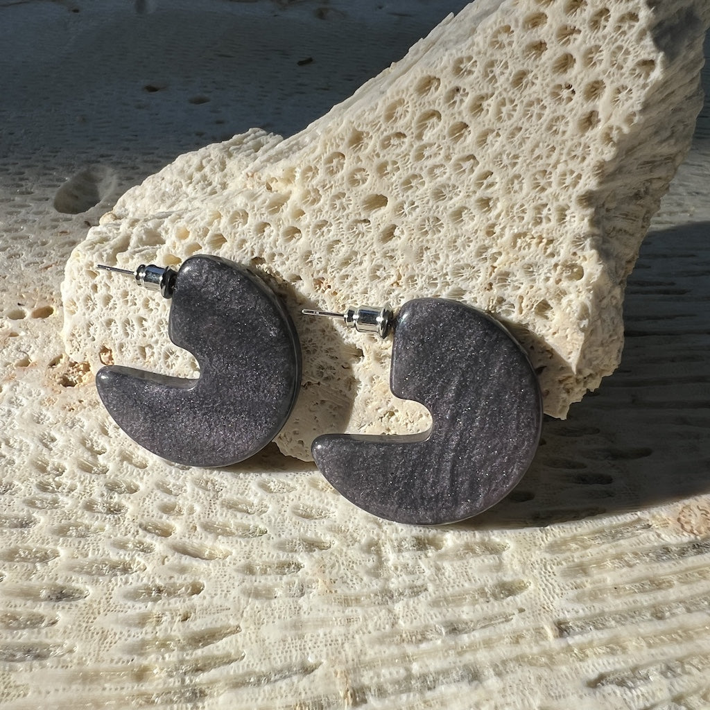 Pair of stone-like earrings on a textured surface
