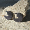 Pair of stone-like earrings on a textured surface
