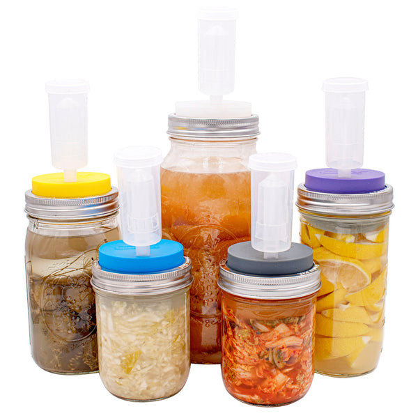 Set of mason jars with various colorful lids on a white background
