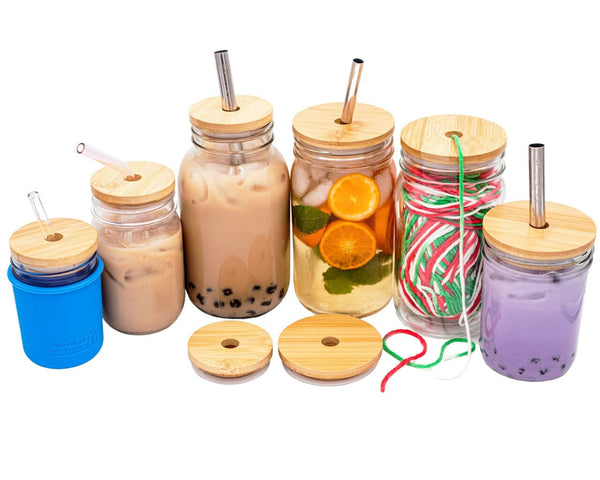 Set of mason jars with wooden lids and straws on a white background