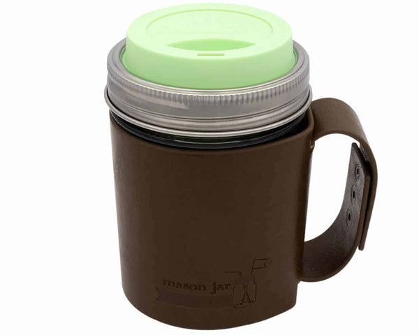 Brown mason jar with a green lid on a white background