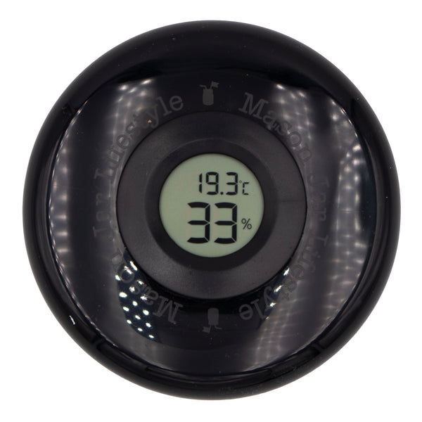 Black digital thermometer with temperature and humidity display on a white background