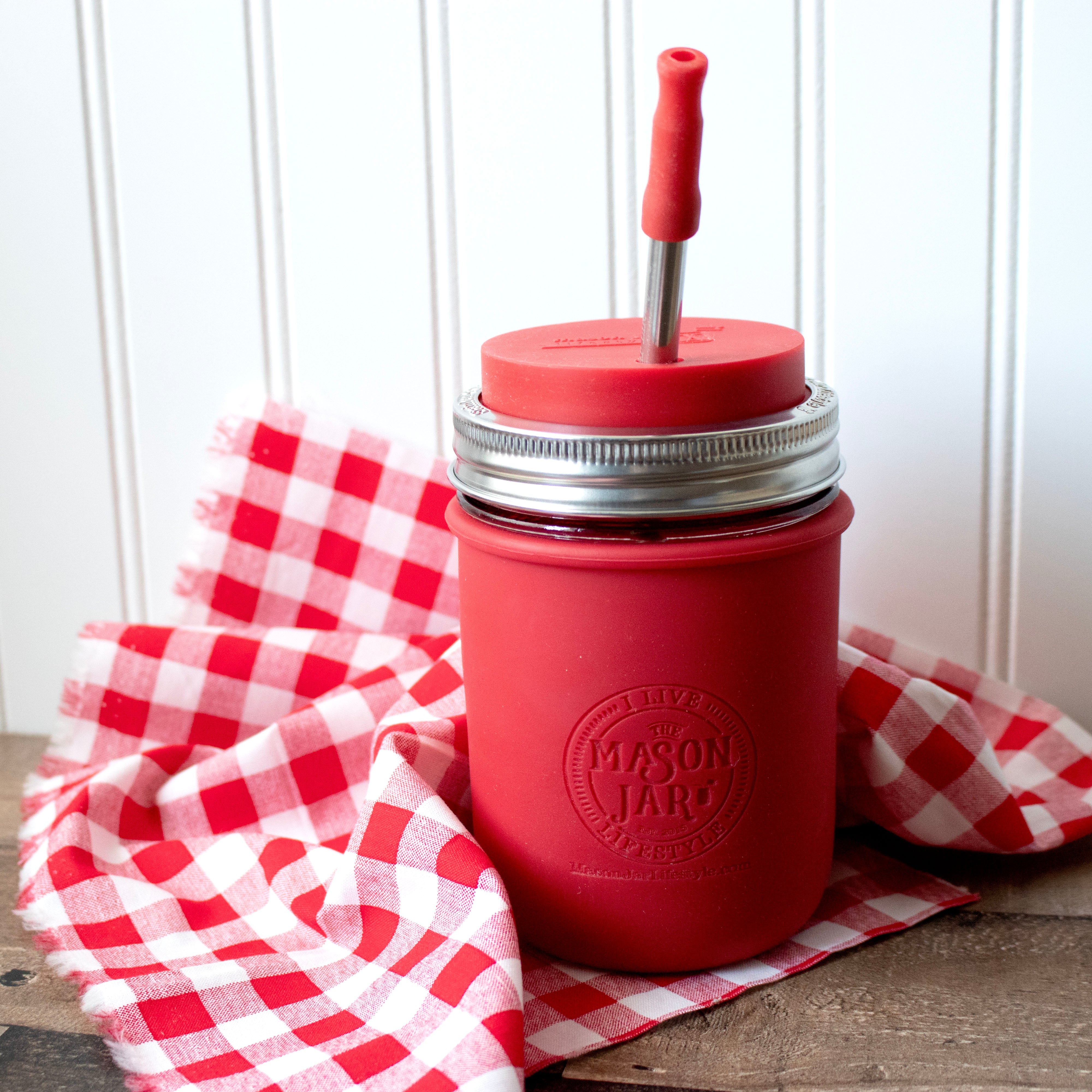 Red mason jar with a straw lid on a red and white checkered cloth