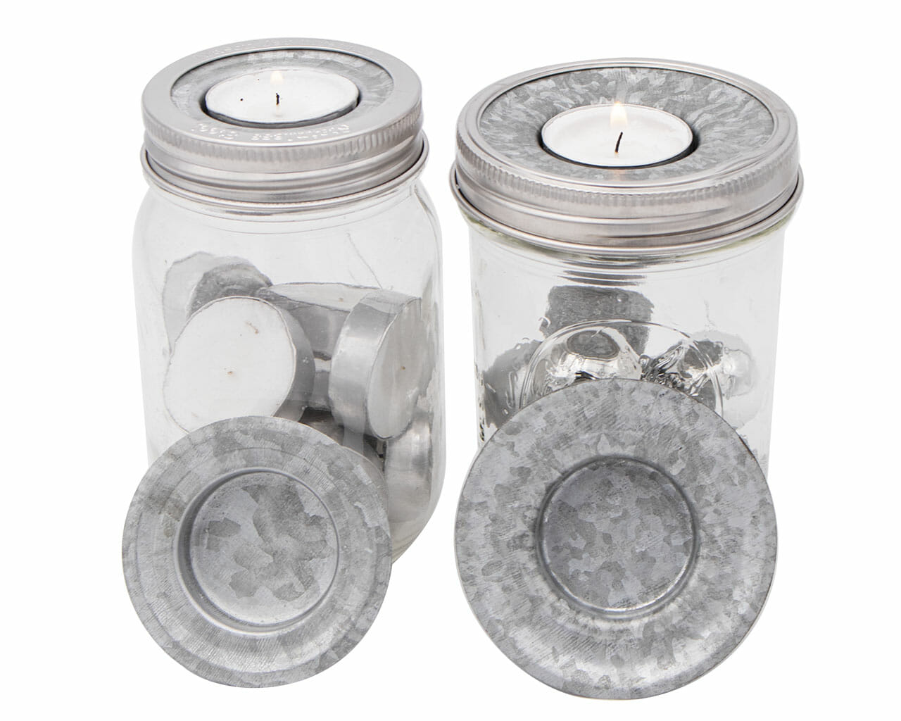 Two clear jars with metal lids containing tea lights on a white background