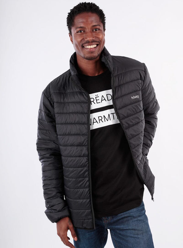 Man wearing a black puffer jacket over a black t-shirt with text on a white background