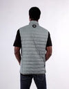 Person wearing a gray puffer vest on a white background