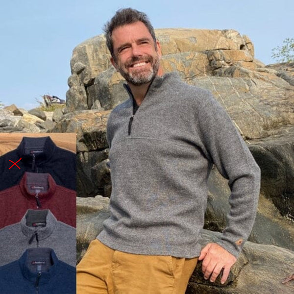 Man wearing a gray sweater with a scenic background