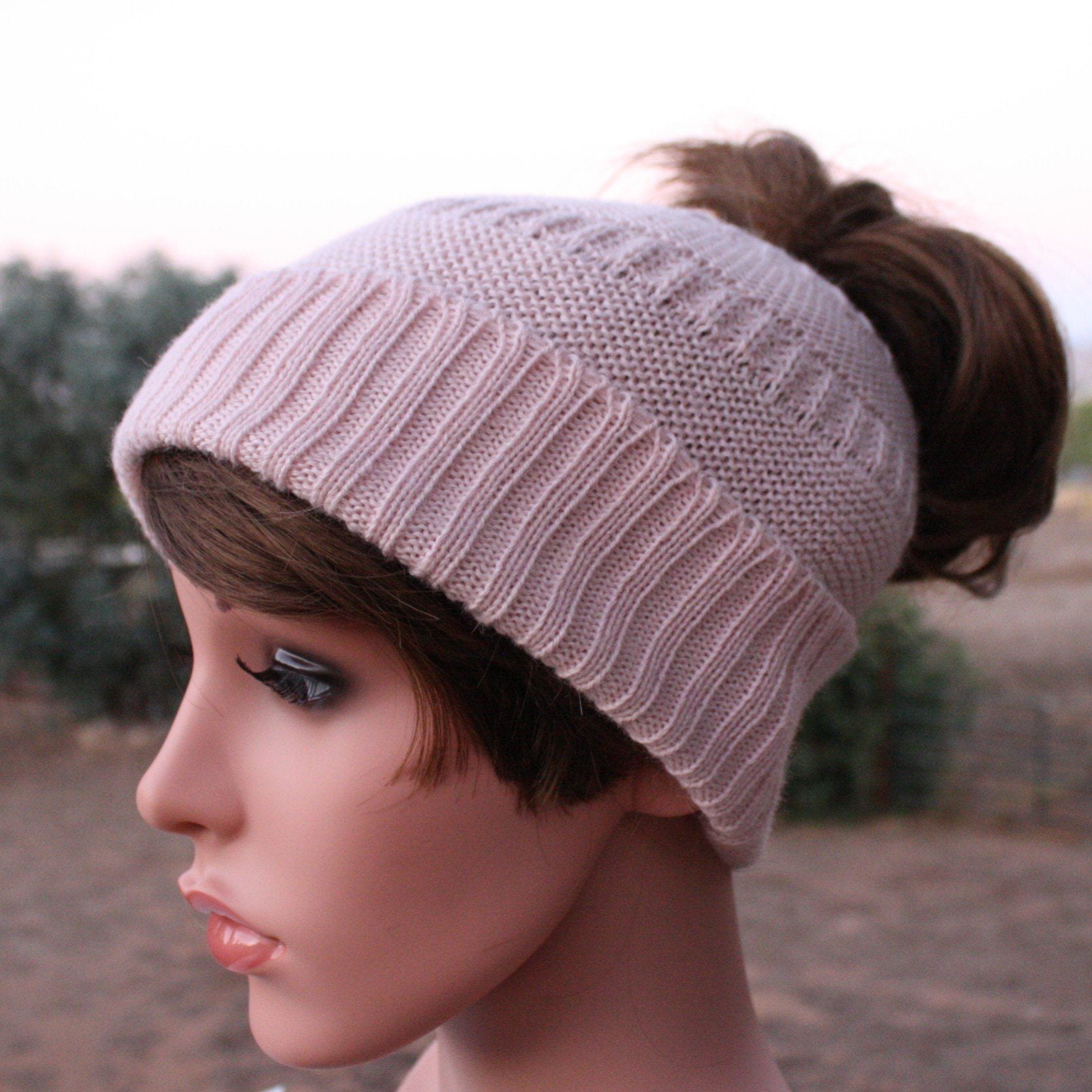 Close-up of soft alpaca and acrylic knit texture on messy bun ponytail hat