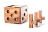 Wooden dice-shaped container with cylindrical wooden pieces on a white background