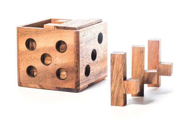 Wooden dice-shaped container with cylindrical wooden pieces on a white background