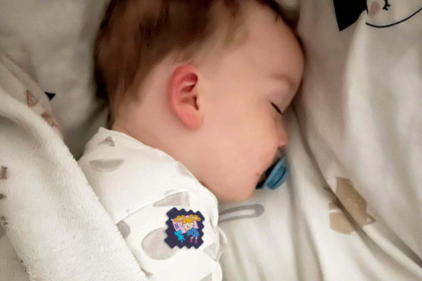 Baby sleeping with a pacifier in a crib