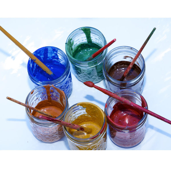 Jars of colored paint with wooden sticks in each, on a white background