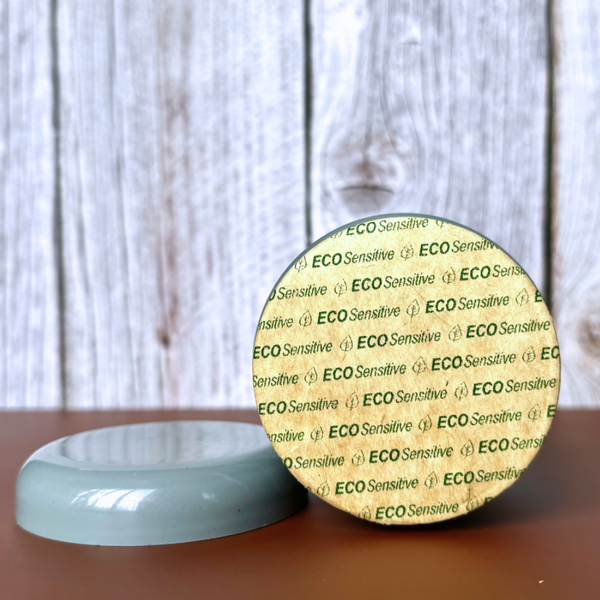Round container labeled 'ECO Sensitive' on a wooden surface with a blurred background