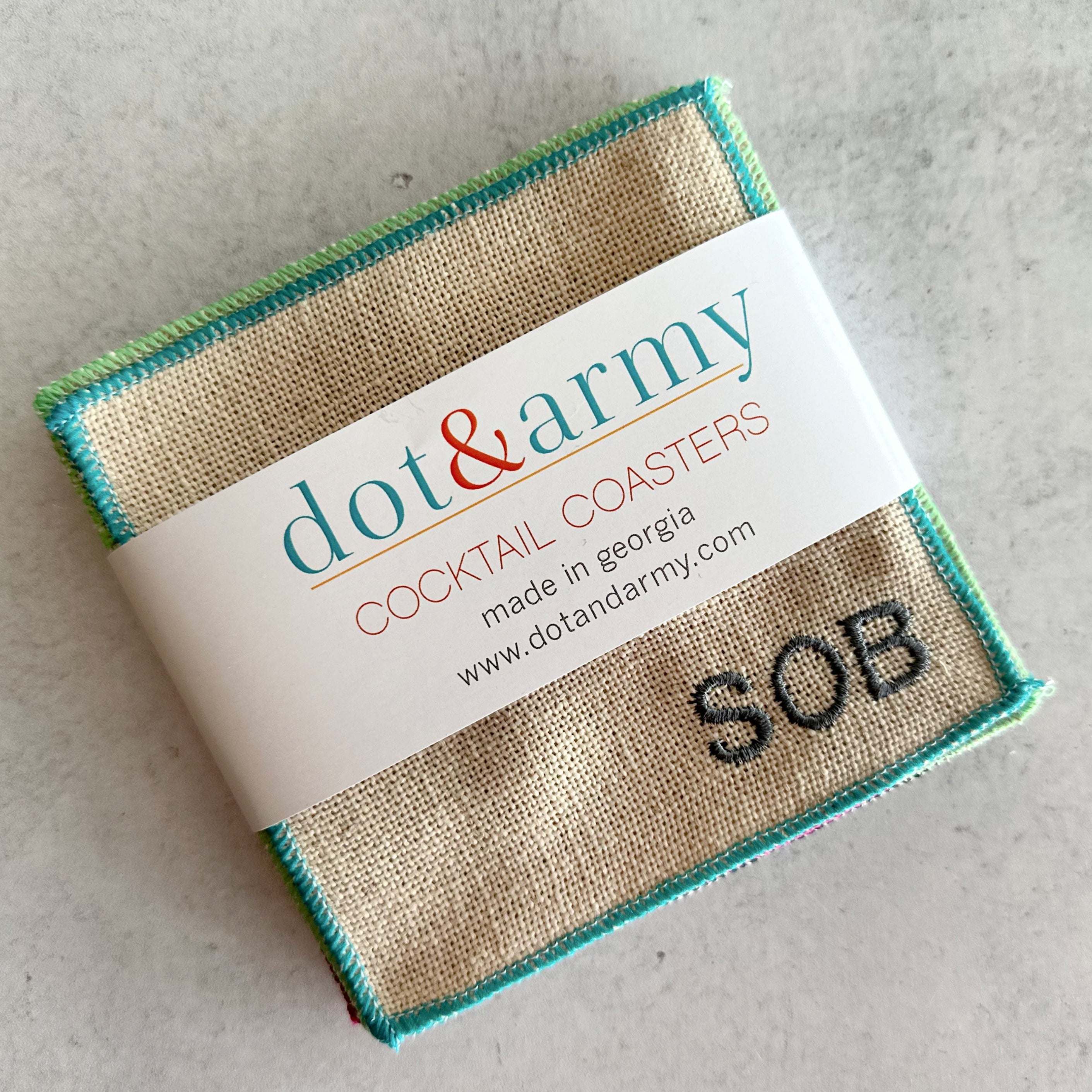Set of 8 colorful sweary cocktail coasters laid out flat, each featuring a bold letter representing a swear word, with bright colored edging on a linen poly blend material