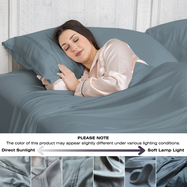 Woman sleeping under gray bedding with a light gray pillow and blanket.