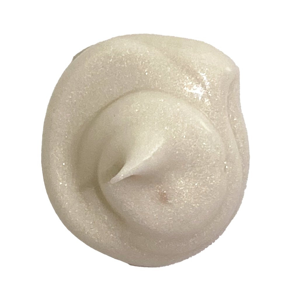 Close-up of a swirl of light-colored cream or frosting on a white background