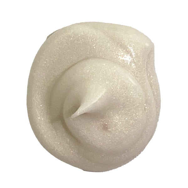 Close-up of a swirl of light-colored cream or frosting on a white background