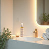 Model applying Glimmer Goddess organic firming body oil to skin for hydrating glow and firming effect