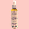Glimmer Goddess organic body oil displayed with natural botanical ingredients including rosehip and evening primrose