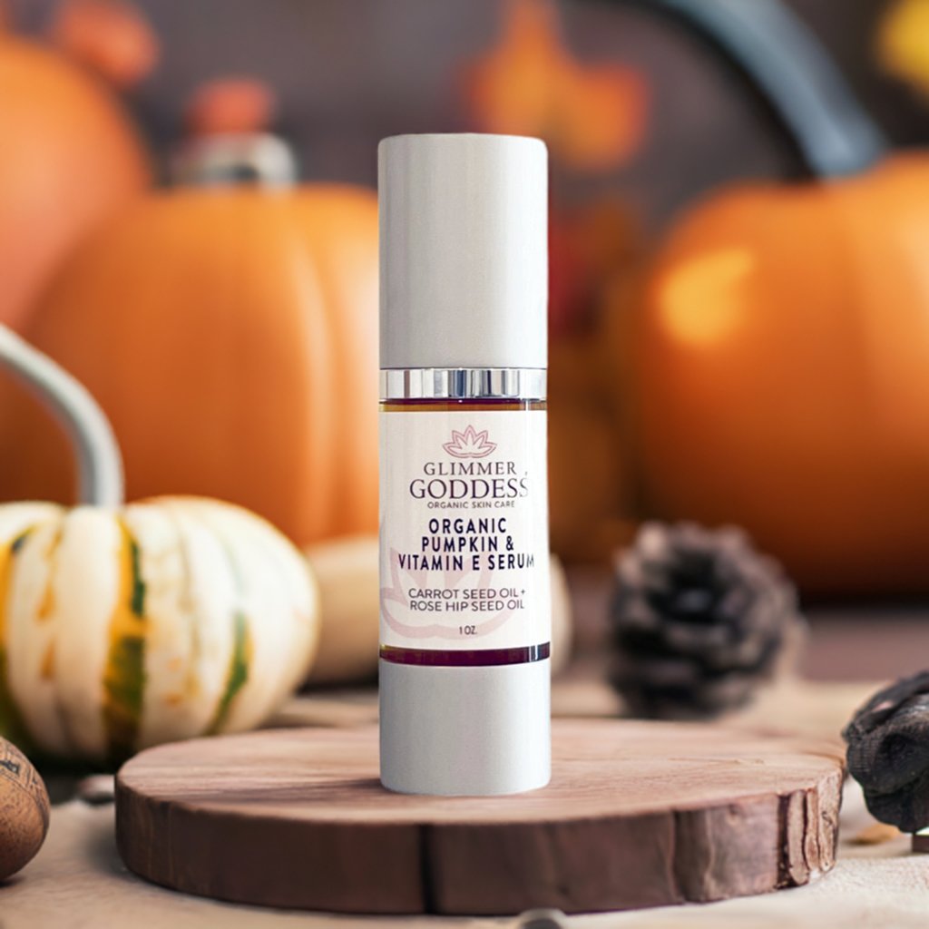 Glimmer Goddess skincare serum bottle with pumpkins and pinecones in the background