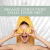 Person with a yellow towel on their head holding orange slices, with 'Glimmer Goddess' branding above.