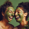 Two women with green face masks on a green background
