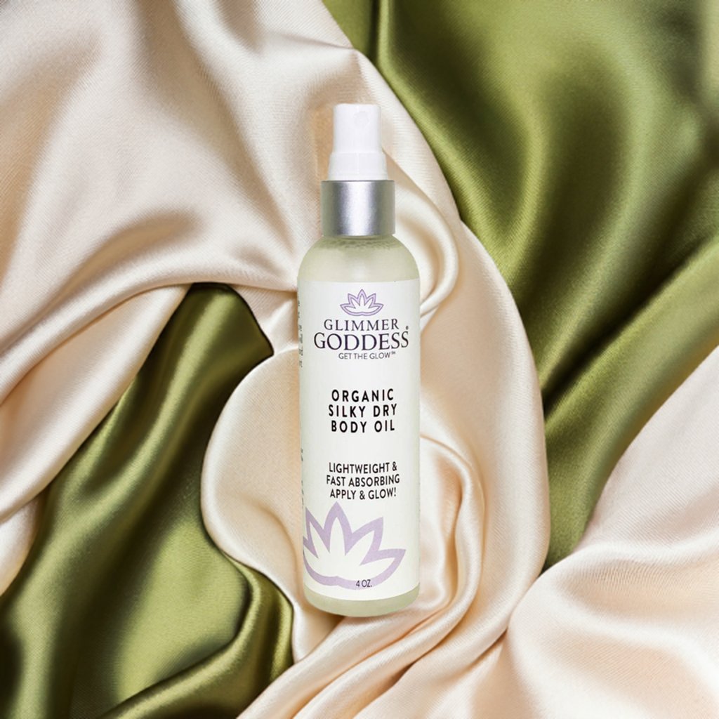 Glimmer Goddess organic silky dry body oil bottle on satin fabric