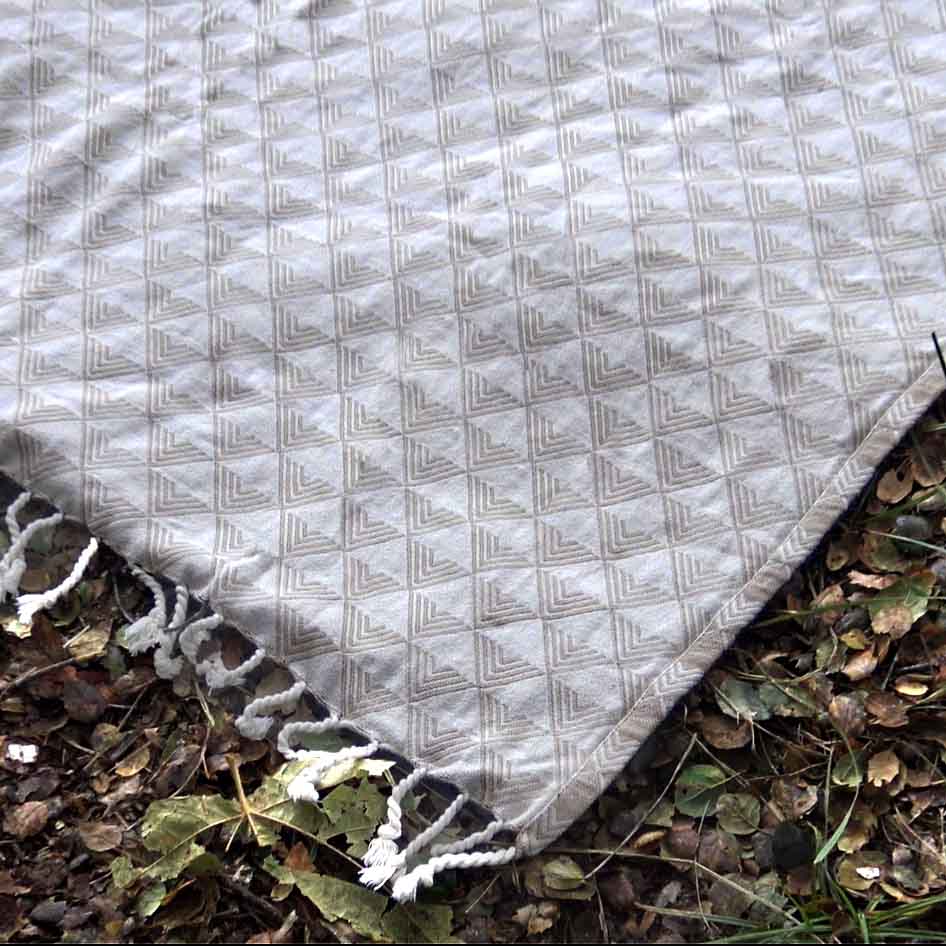 Textured blanket with geometric pattern on a natural background