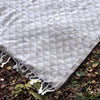 Textured blanket with geometric pattern on a natural background