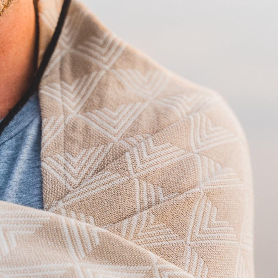 Close-up of a textured beige fabric with a geometric pattern on a blurred background