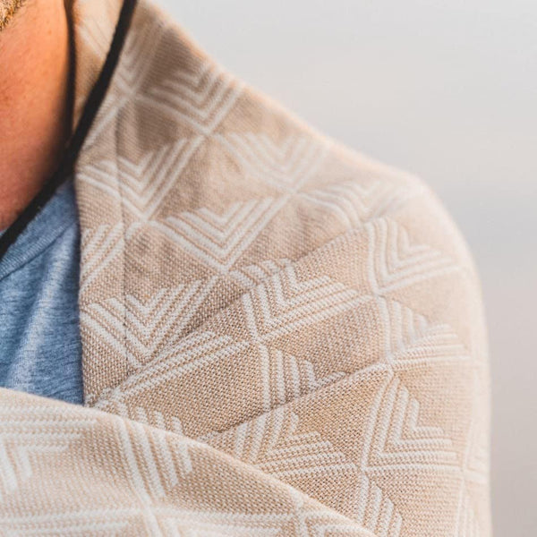 Close-up of a textured beige fabric with a geometric pattern on a blurred background