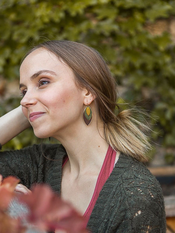 Close-up of brass-plated recycled metal oval disc autumn earrings by Fair Anita
