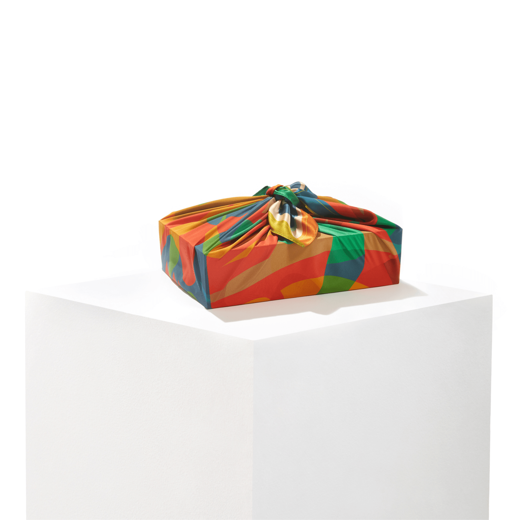 Patient Fire furoshiki wrap styled as a reusable gift wrap around a present, showcasing the silk print detail