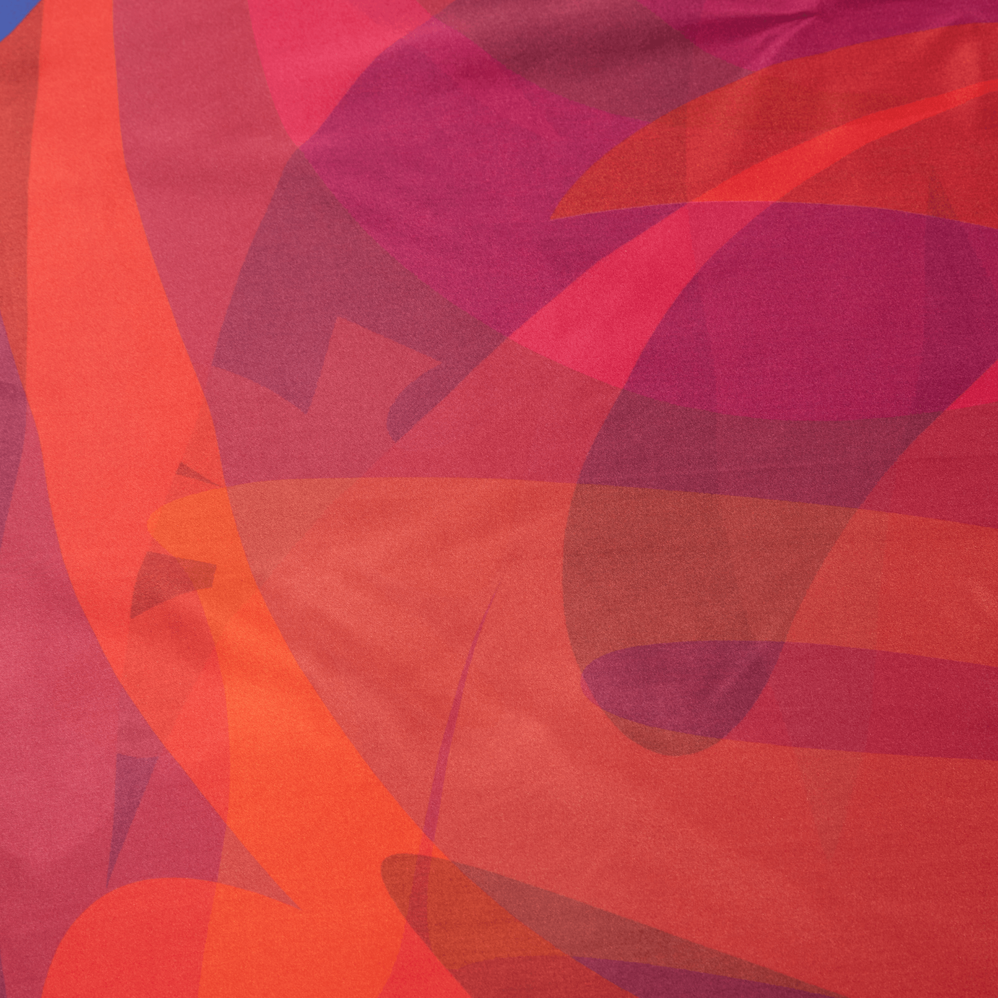 Close-up of colorful fabric with abstract patterns in reds and oranges.