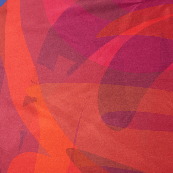 Close-up of colorful fabric with abstract patterns in reds and oranges.
