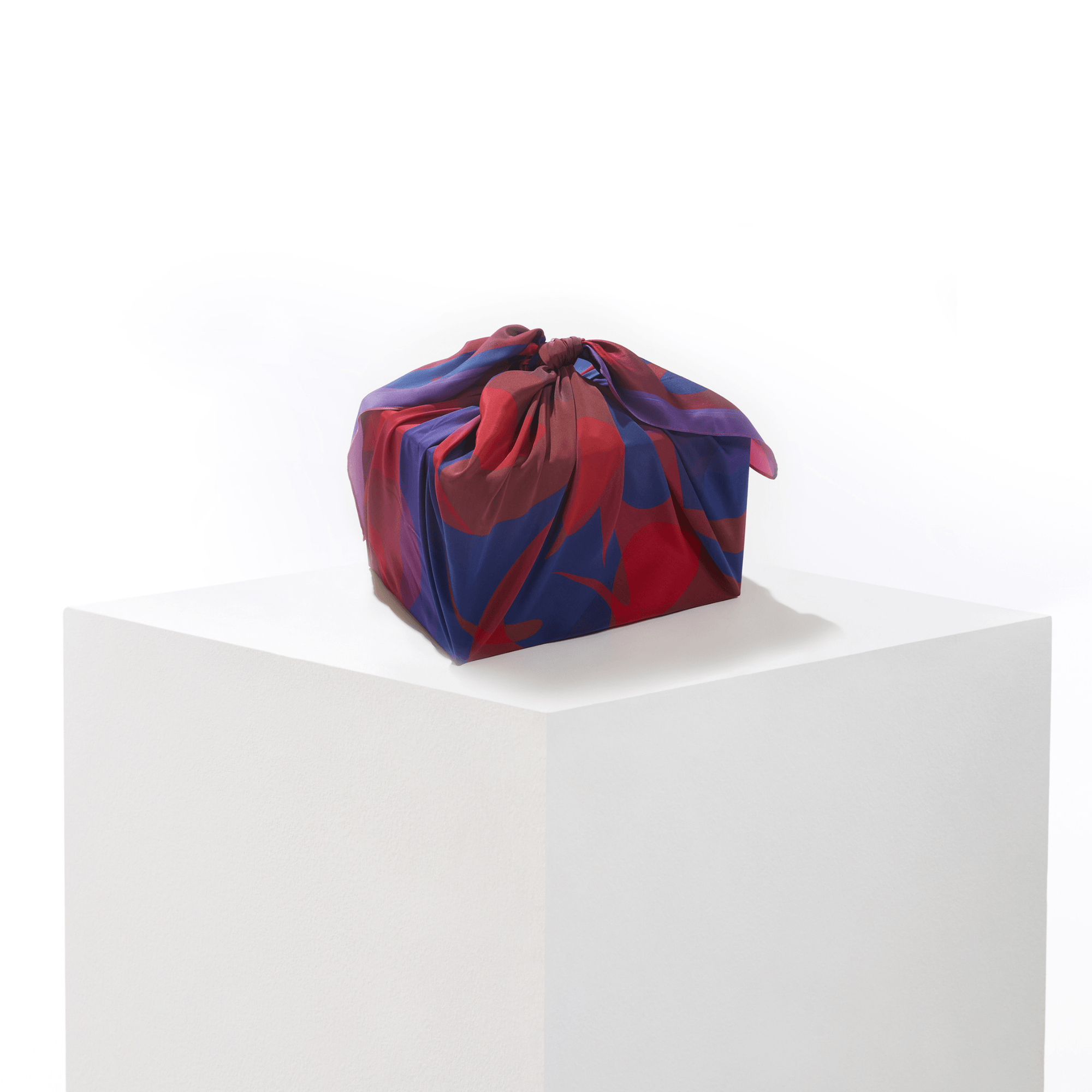 Patient Heart silk furoshiki wrap folded and tied as a reusable gift bag, styled as an eco-friendly gift wrapping option