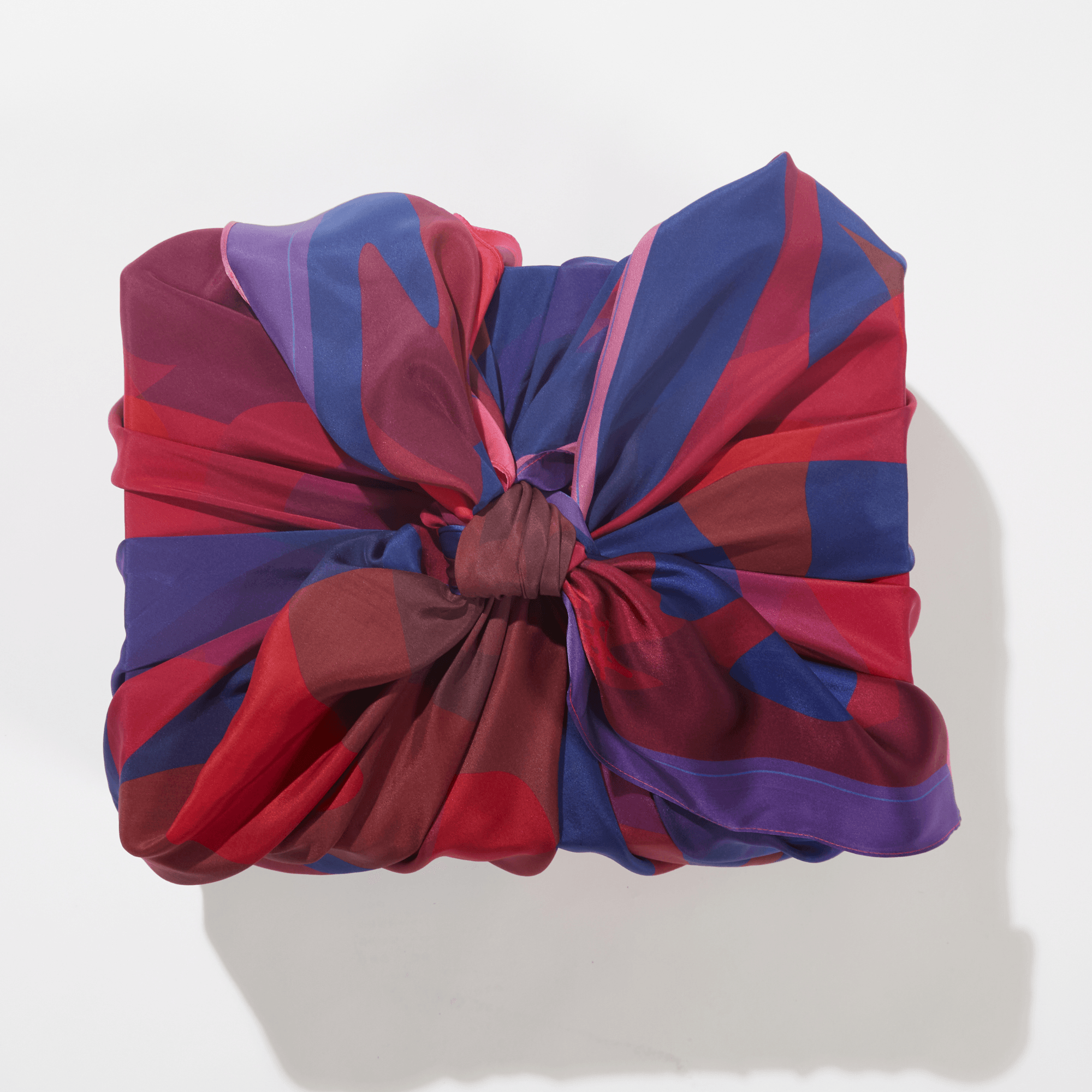 Patient Heart 50-inch silk furoshiki wrap by Essery Waller styled as a wrapped gift, sustainable alternative to single-use wrapping paper