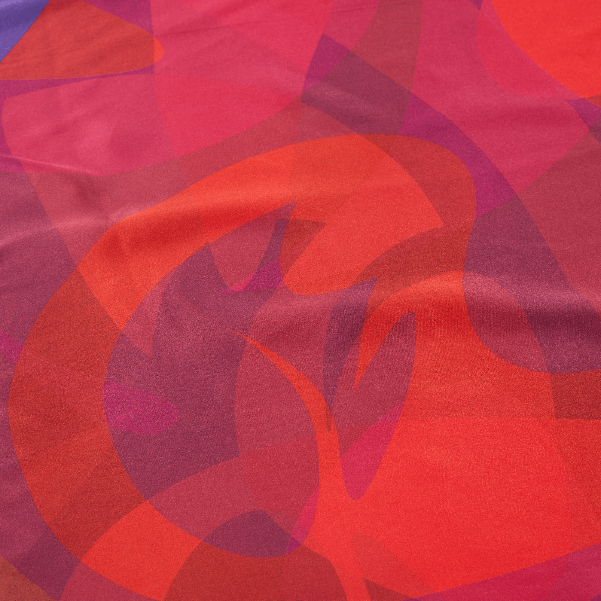 Abstract pattern of red and pink shapes on a fabric background