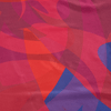 Abstract pattern of red, pink, and blue shapes on a fabric background