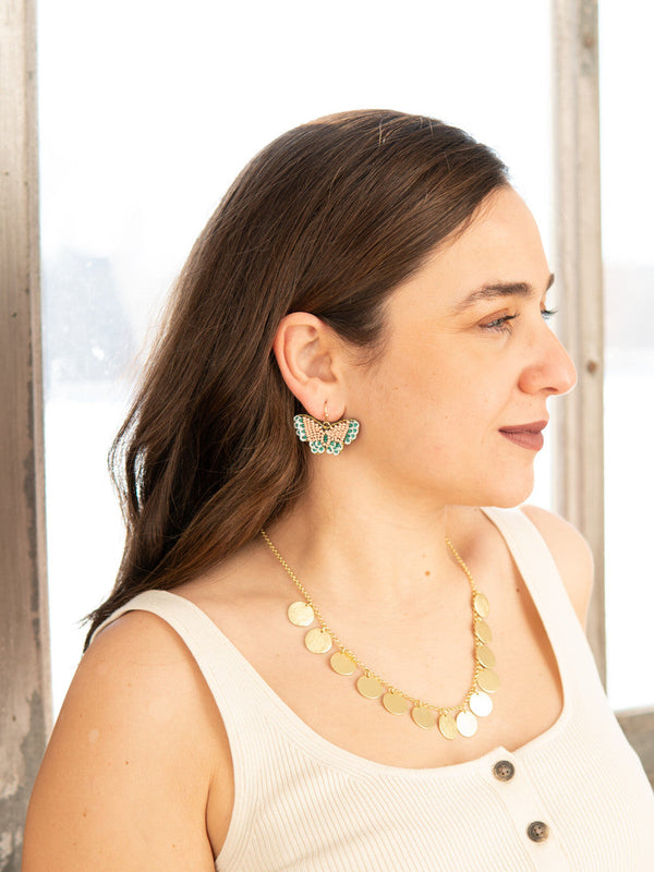 Close-up of Fair Anita beaded butterfly earrings in peach and blue glass beads